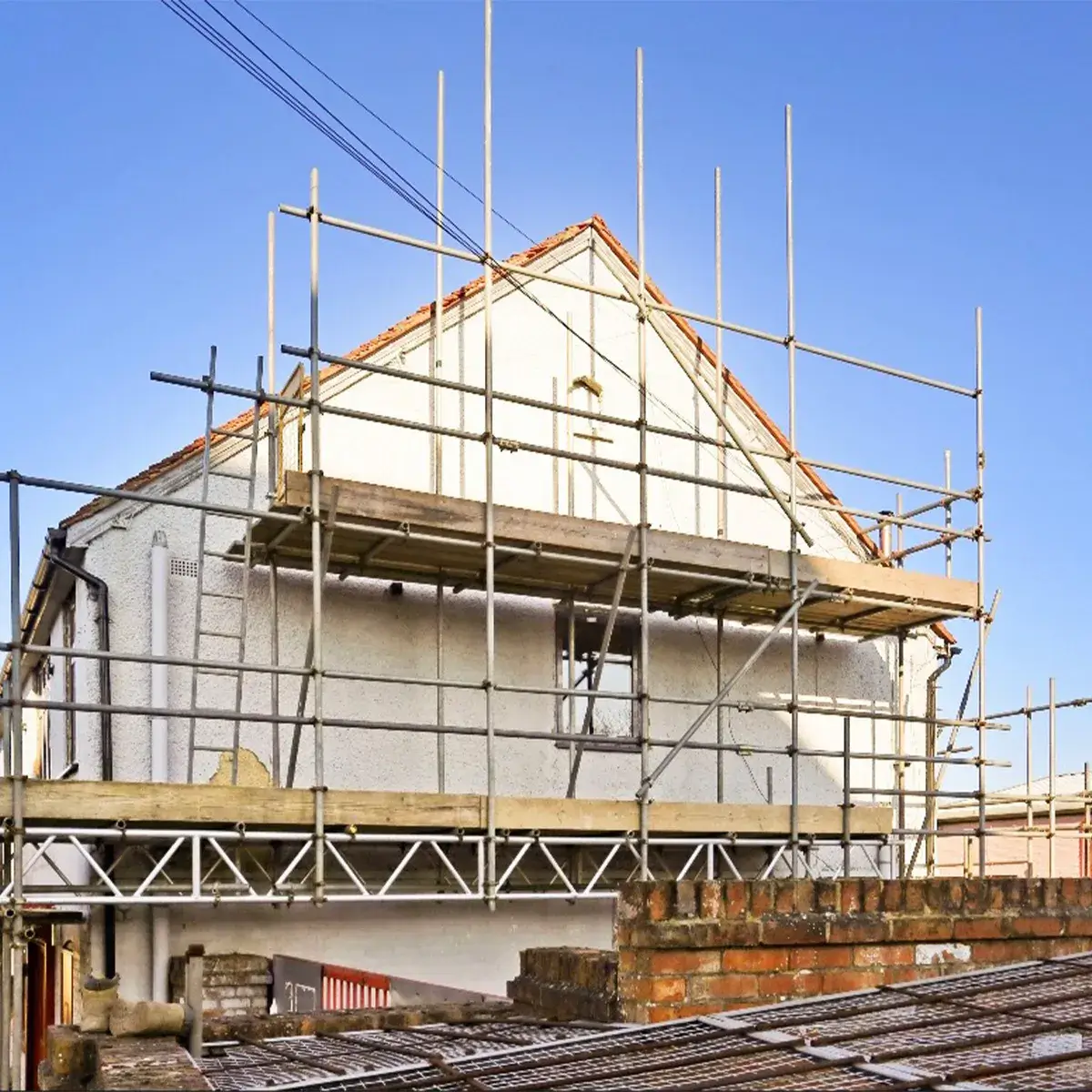 a house under construction with scaffolding on the roof