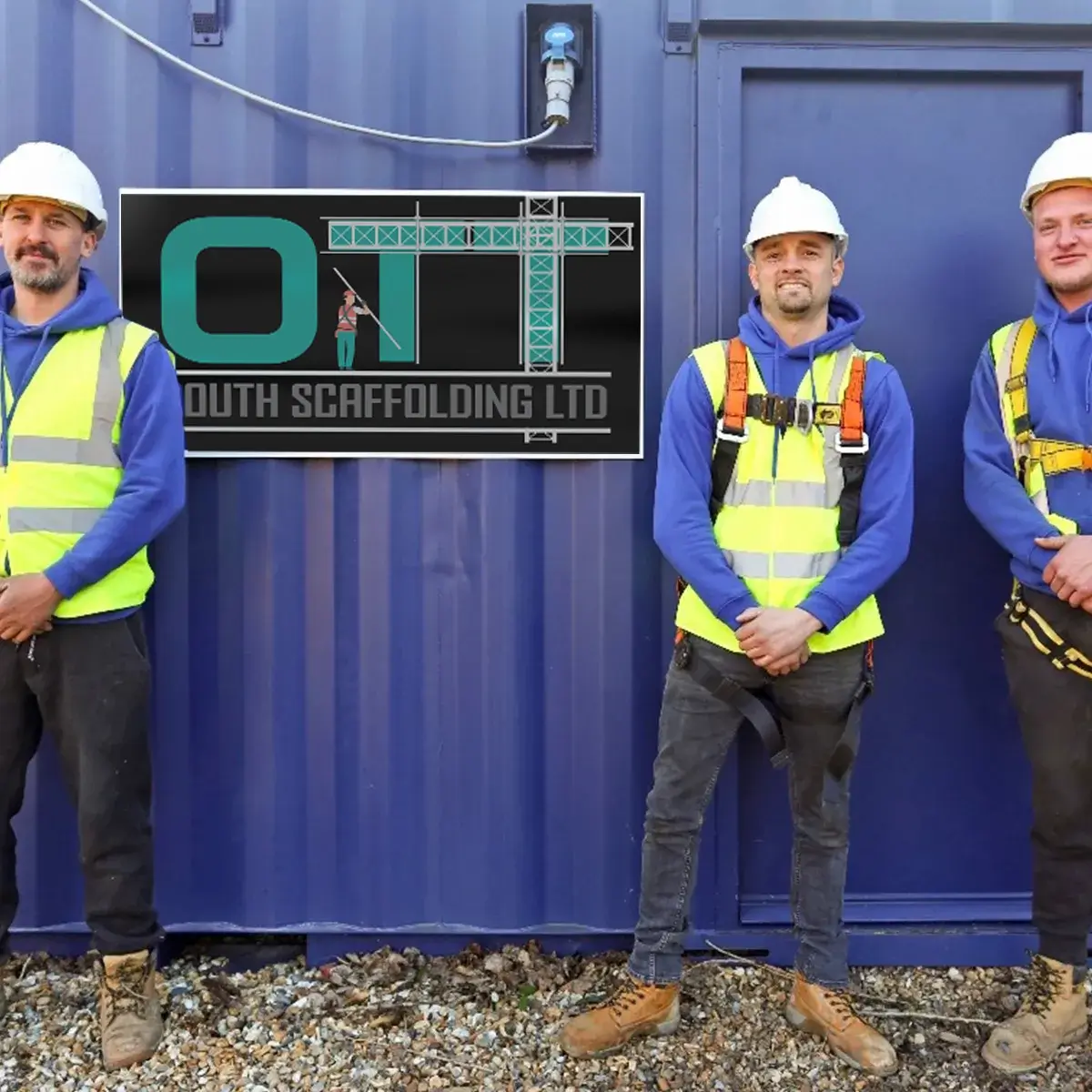 three men in safety vests standing next to a blue container