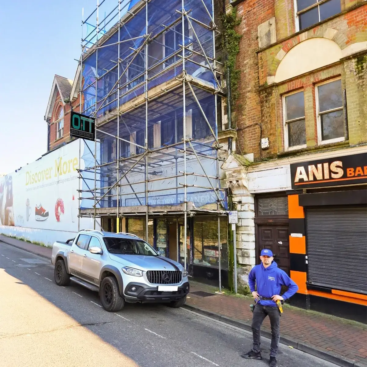 a man standing on the side of a road next to a building