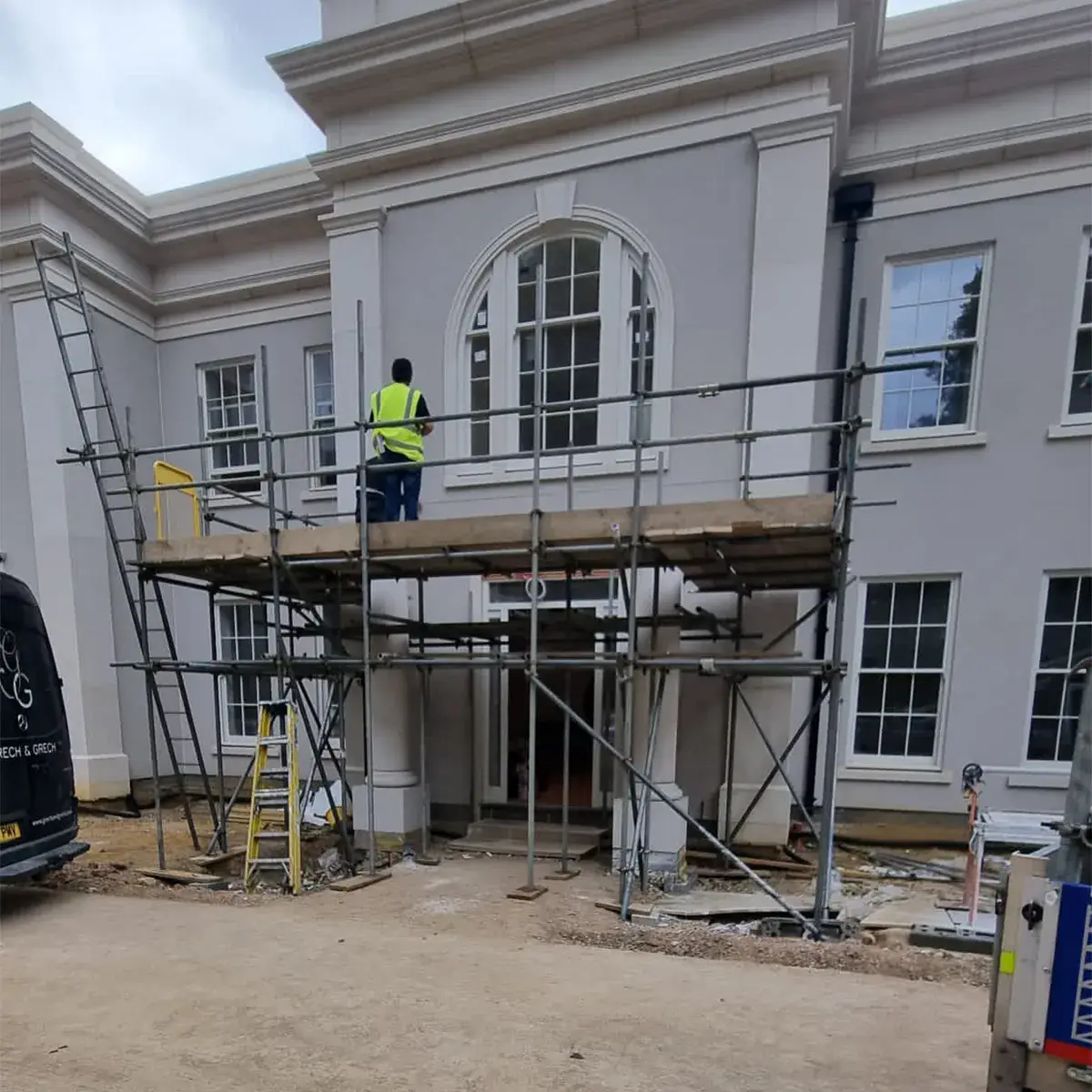 a man standing on a scaffold in front of a building