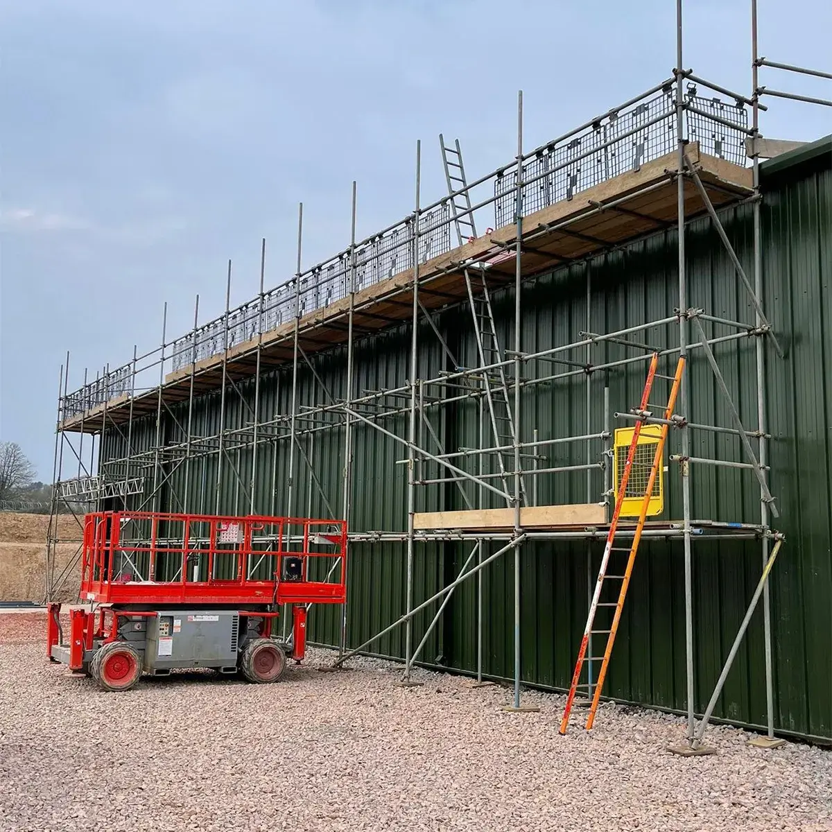 a green building with scaffolding and a red scaffold